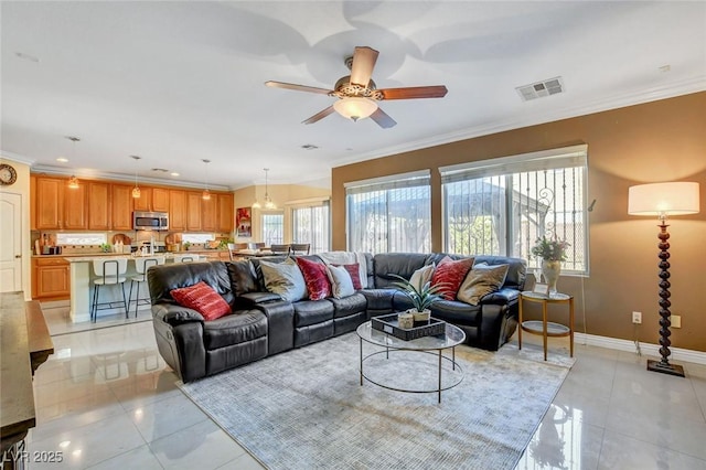 tiled living room featuring ornamental molding, a healthy amount of sunlight, and ceiling fan