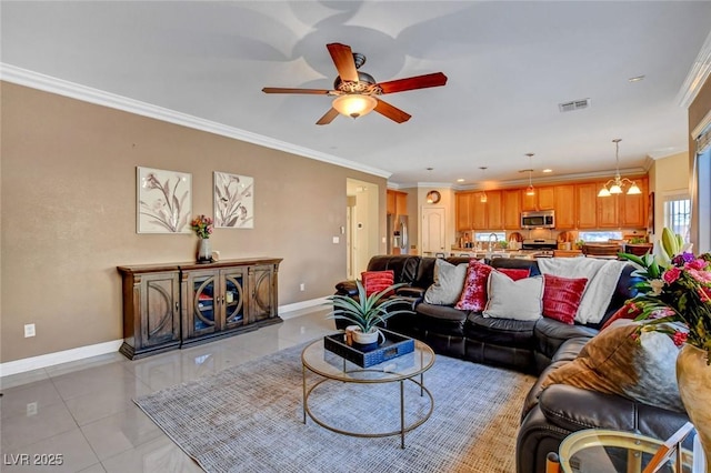 living room featuring light tile patterned floors, crown molding, ceiling fan with notable chandelier, and sink