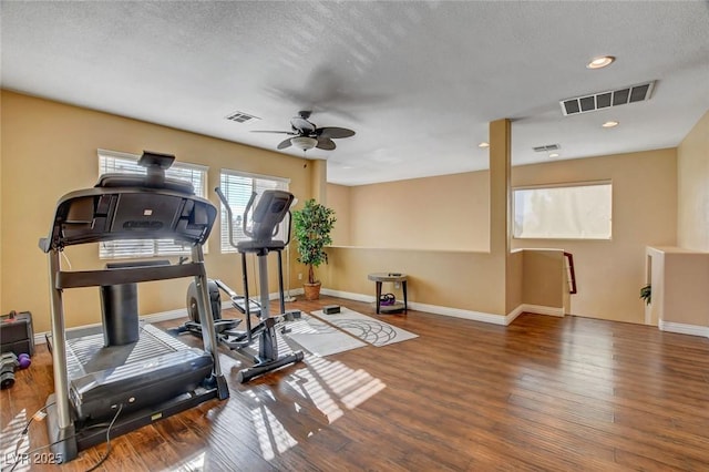 workout room with dark hardwood / wood-style floors, a textured ceiling, and ceiling fan