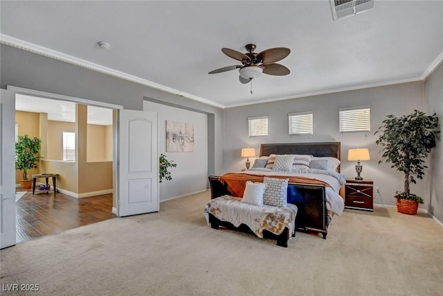 carpeted bedroom featuring multiple windows, crown molding, and ceiling fan