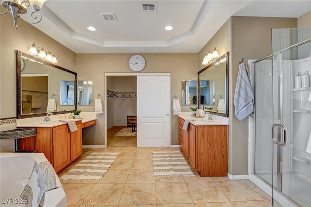 bathroom featuring tile patterned flooring, vanity, a tray ceiling, and shower with separate bathtub