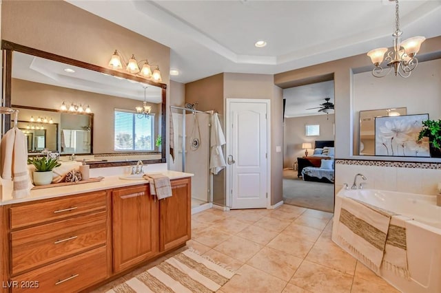 bathroom featuring a raised ceiling, vanity, ceiling fan with notable chandelier, and tile patterned floors