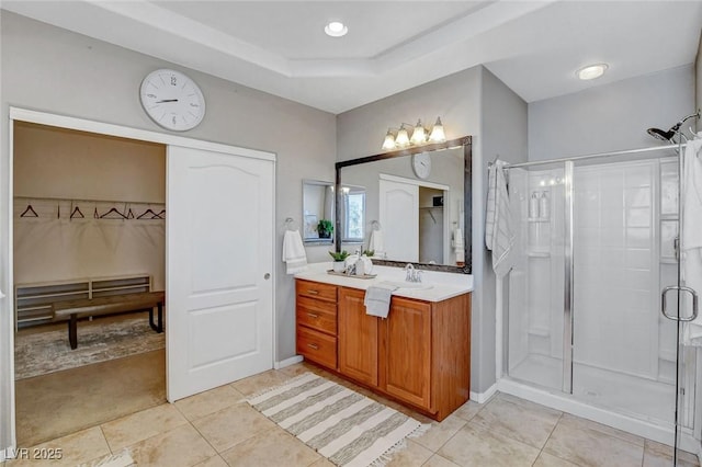 bathroom with tile patterned flooring, an enclosed shower, and vanity