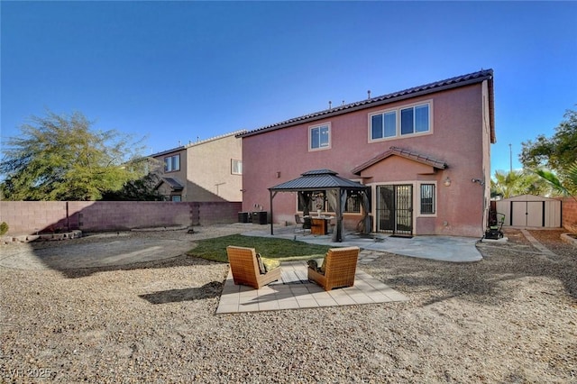 back of property featuring a gazebo, a patio area, and a shed