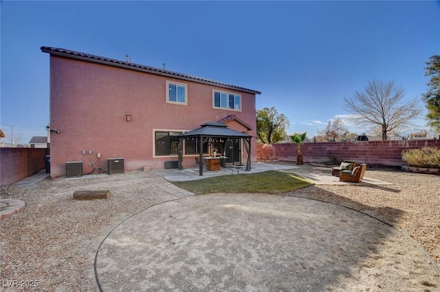 rear view of property with central AC unit, a gazebo, and a patio