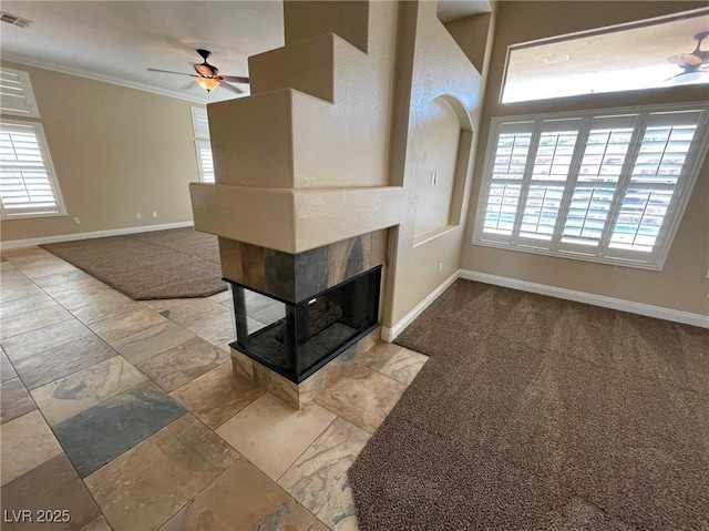 unfurnished living room featuring ceiling fan, ornamental molding, and a fireplace