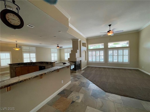 kitchen featuring hanging light fixtures, ceiling fan, sink, and ornamental molding