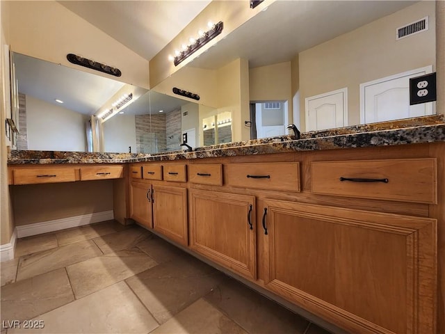 bathroom featuring lofted ceiling and vanity