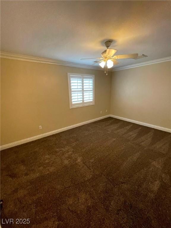 empty room featuring ceiling fan, dark carpet, and ornamental molding