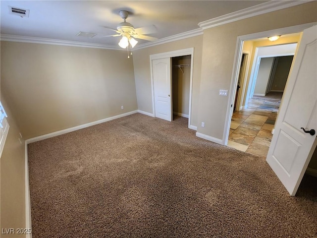 unfurnished bedroom with ceiling fan, carpet flooring, a closet, and crown molding