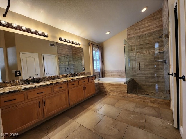 bathroom featuring vanity, vaulted ceiling, and independent shower and bath