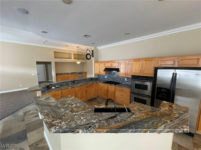 kitchen featuring dark stone counters, sink, stainless steel appliances, and ornamental molding