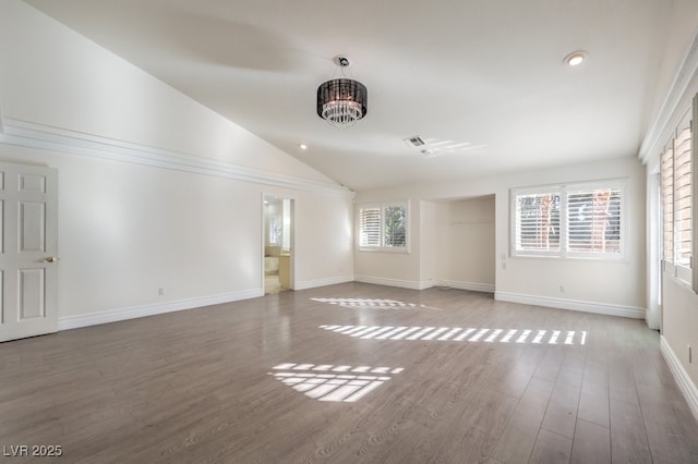 unfurnished living room featuring hardwood / wood-style flooring, a chandelier, and vaulted ceiling