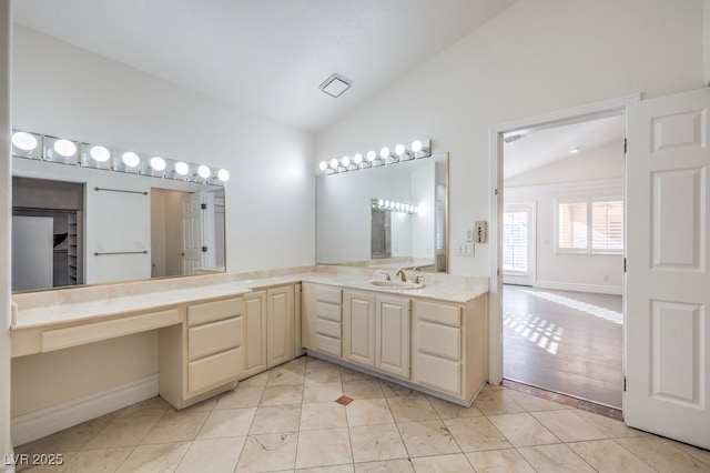 bathroom with tile patterned floors, vanity, and vaulted ceiling