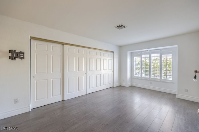 unfurnished bedroom featuring a closet and hardwood / wood-style flooring