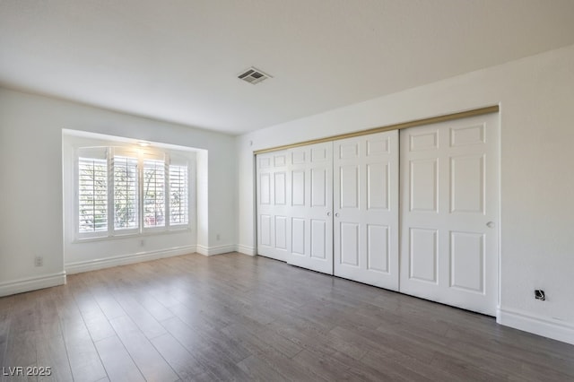 unfurnished bedroom with a closet and hardwood / wood-style flooring