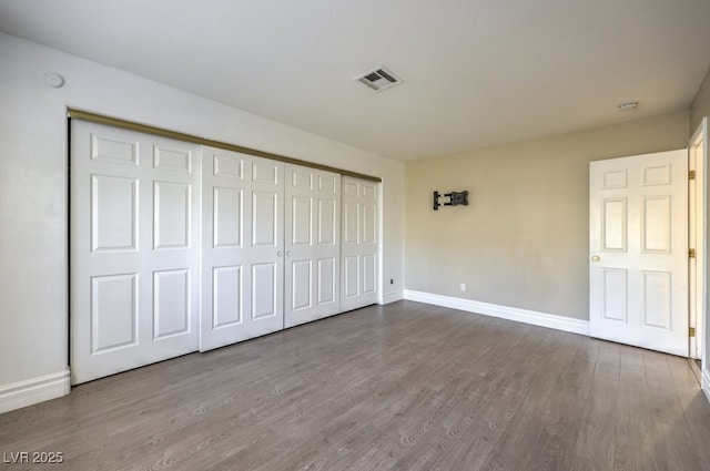 unfurnished bedroom featuring hardwood / wood-style flooring and a closet