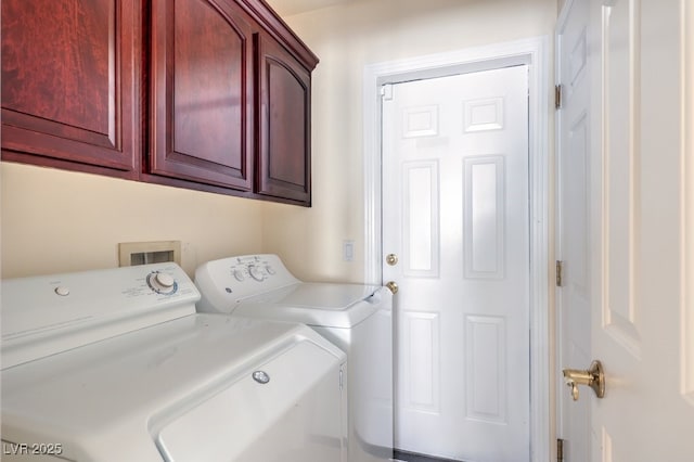 laundry area featuring washing machine and clothes dryer and cabinets