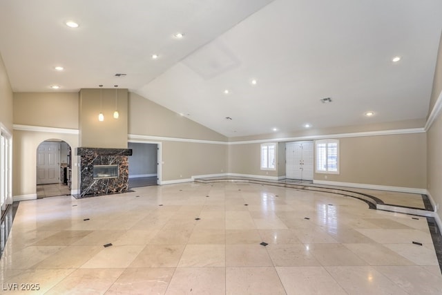 unfurnished living room featuring high vaulted ceiling, light tile patterned floors, and a high end fireplace