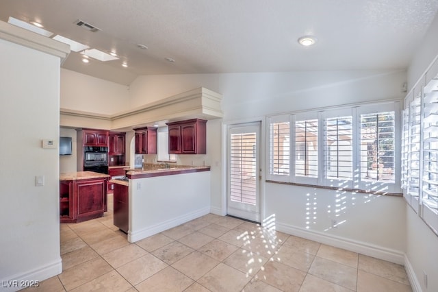 kitchen featuring oven, a textured ceiling, light tile patterned floors, sink, and lofted ceiling