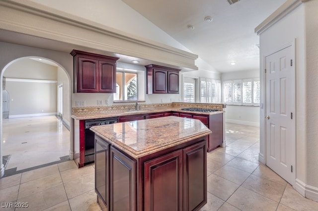 kitchen featuring dishwasher, light tile patterned floors, sink, a kitchen island, and lofted ceiling