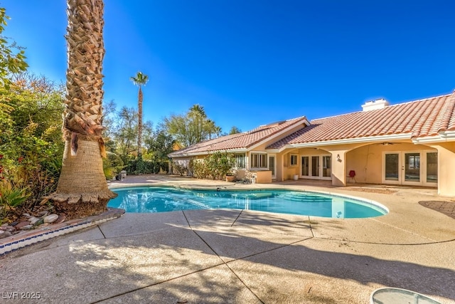 view of swimming pool featuring french doors and a patio area