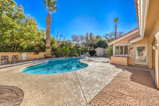 view of pool with a storage unit and a patio