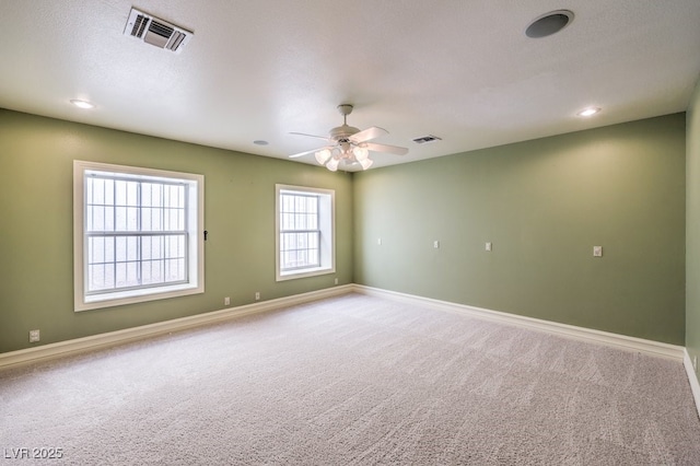 carpeted spare room with ceiling fan and a textured ceiling