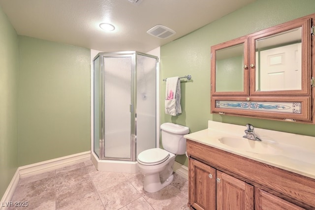 bathroom with toilet, vanity, a shower with door, and a textured ceiling