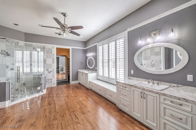 bathroom featuring ceiling fan, a shower with shower door, hardwood / wood-style floors, and vanity