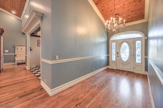 entryway featuring wood ceiling, crown molding, a chandelier, and hardwood / wood-style flooring