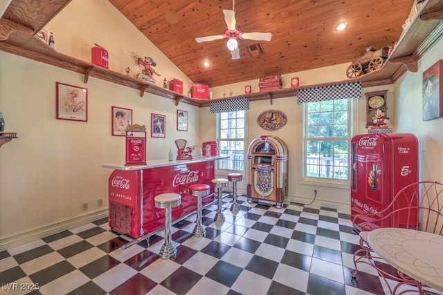 game room featuring high vaulted ceiling, indoor bar, wood ceiling, and ceiling fan