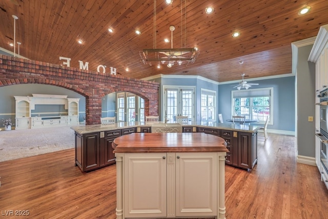 kitchen featuring wood counters, dark brown cabinets, french doors, and a center island