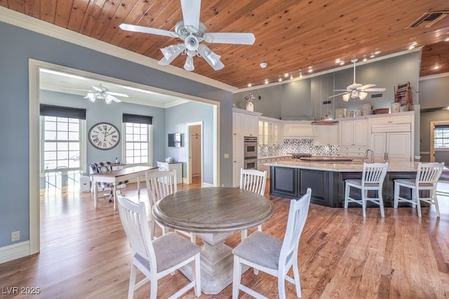 dining space with light wood-type flooring, wood ceiling, and ornamental molding