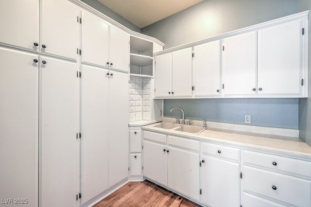 kitchen featuring sink, white cabinetry, and light hardwood / wood-style flooring