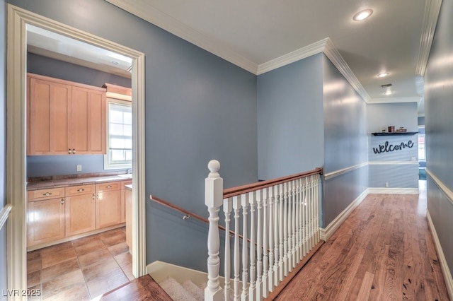 hallway featuring light wood-type flooring and ornamental molding