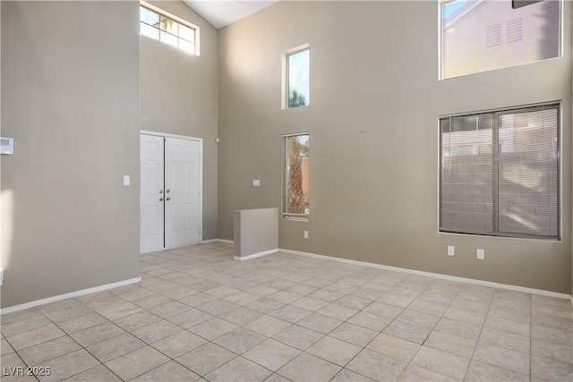 interior space with a high ceiling and light tile patterned flooring