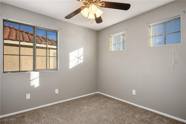 spare room featuring carpet floors, ceiling fan, and a wealth of natural light