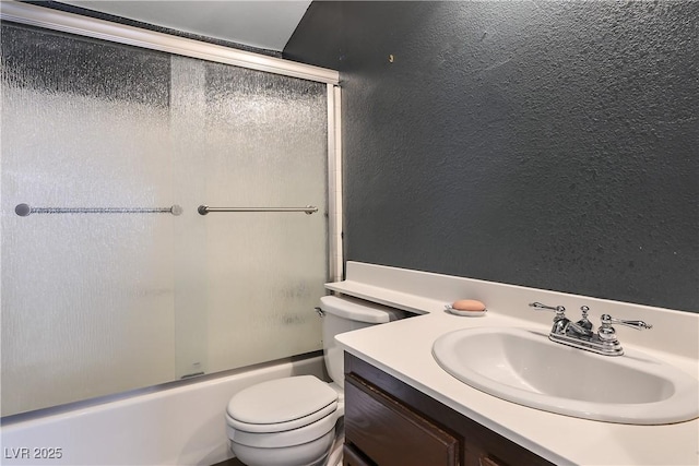 full bathroom featuring combined bath / shower with glass door, vanity, and toilet