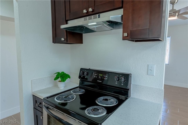 kitchen featuring light hardwood / wood-style floors, ceiling fan, dark brown cabinets, light stone countertops, and black electric range oven