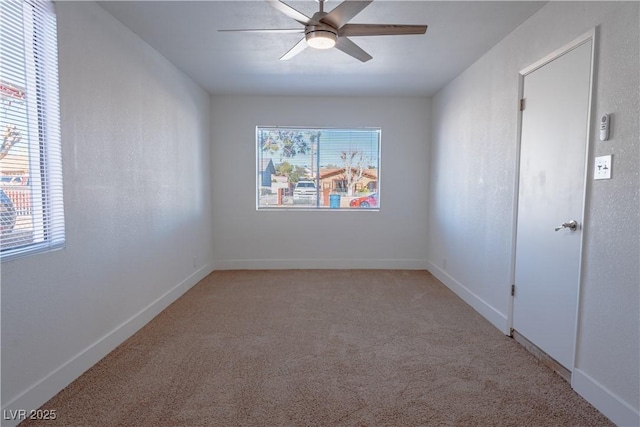 empty room with ceiling fan, plenty of natural light, and light carpet