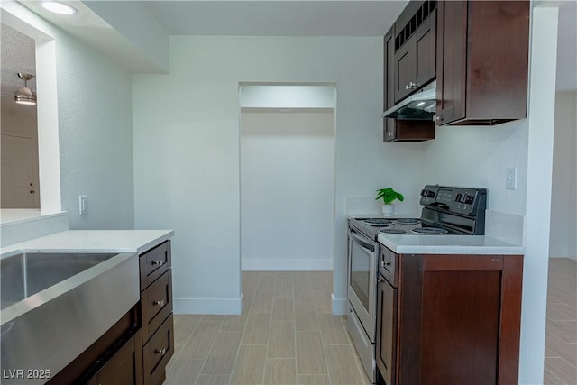 kitchen featuring sink, stainless steel range with electric cooktop, and dark brown cabinetry