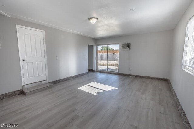 spare room with a wall unit AC and hardwood / wood-style floors