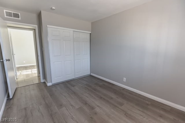 unfurnished bedroom featuring a closet and hardwood / wood-style flooring