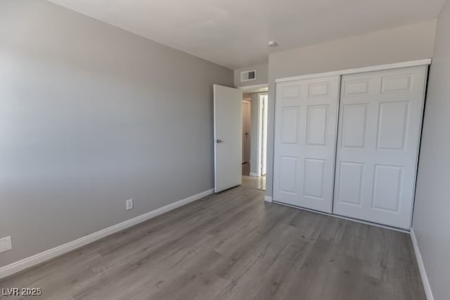 unfurnished bedroom with a closet and light wood-type flooring