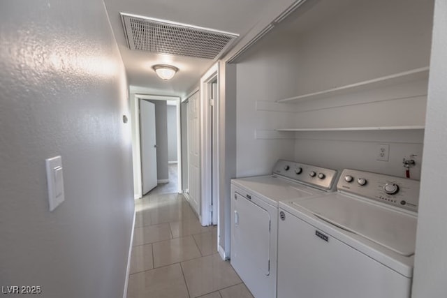 clothes washing area featuring light tile patterned floors and separate washer and dryer