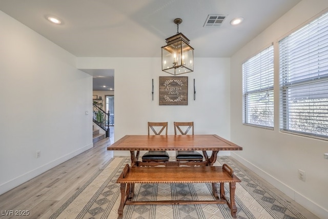 dining space featuring light hardwood / wood-style floors and a notable chandelier