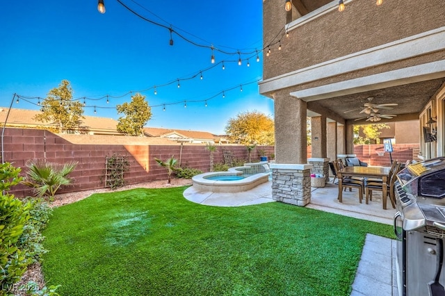 view of yard with ceiling fan, an in ground hot tub, and a patio