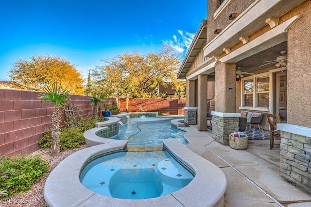 view of swimming pool with ceiling fan, pool water feature, a patio area, and an in ground hot tub