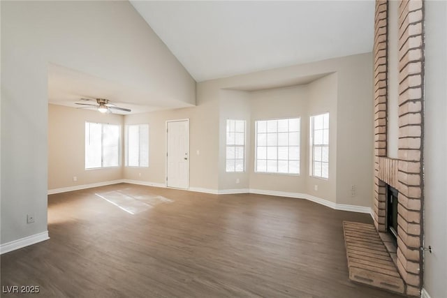 unfurnished living room with vaulted ceiling, ceiling fan, dark hardwood / wood-style flooring, and a brick fireplace